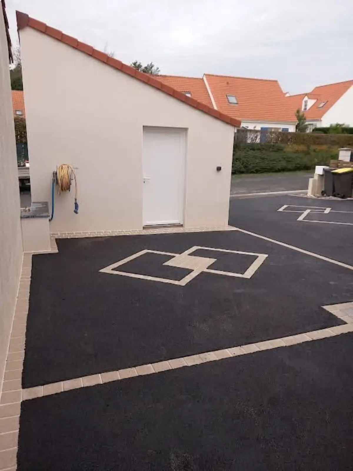 Aménagement de cour en enrobé à Rungis avec motifs décoratifs en pavés