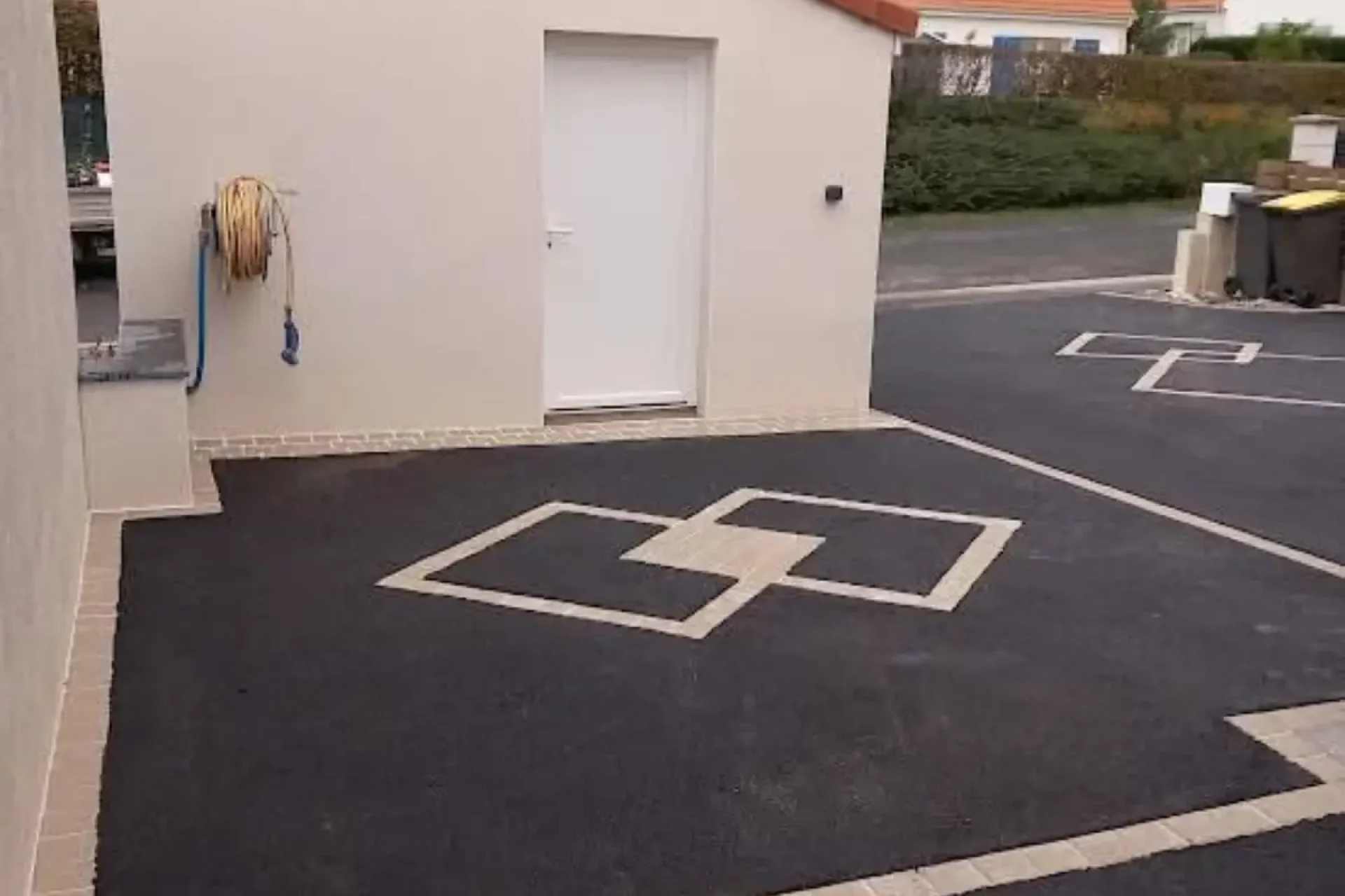 Aménagement de cour en enrobé à Rungis avec motifs décoratifs en pavés